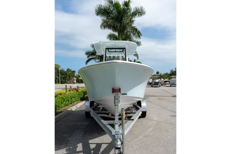 Slide: The Image of 2025 Sportsman Open 212 Center Console boat on trailer, parked near palm trees. - 20