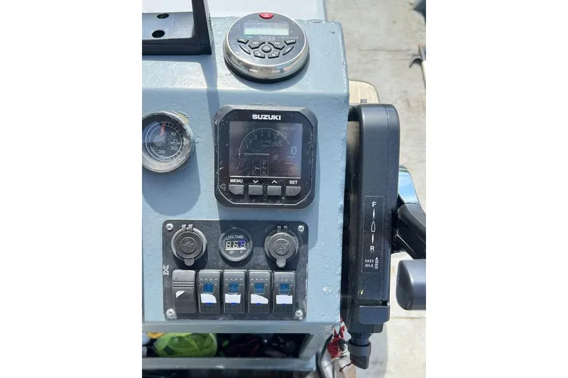 Slide: The Image of Control panel of a 1999 Aluminum Boat featuring Suzuki gauges and switches. - 11