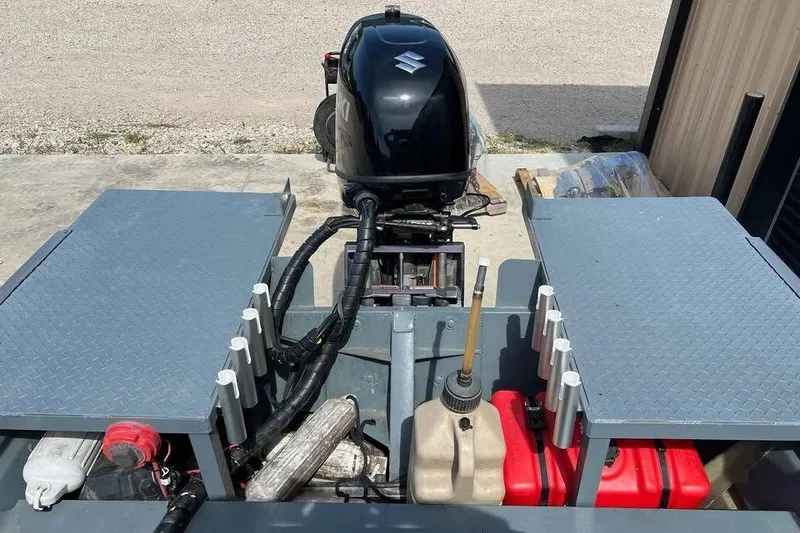 Slide: The Image of 1999 Aluminum Boat with Suzuki outboard motor, featuring storage compartments and fuel containers. - 4