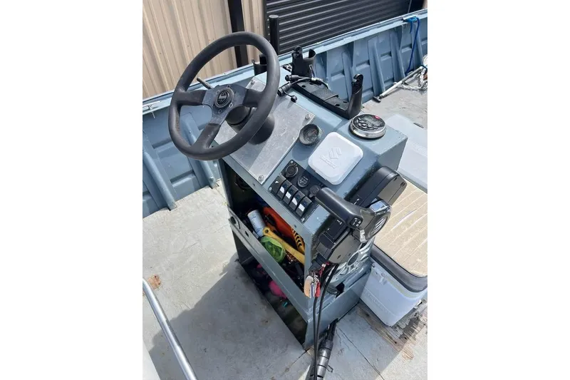 Slide: The Image of 1999 Aluminum Boat steering console with controls and storage compartments. - 6