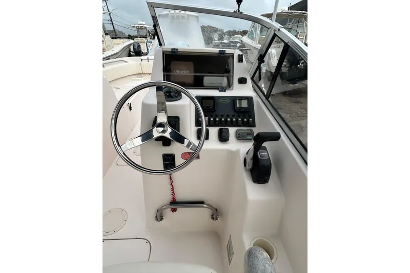 Slide: The Image of 2006 Grady-White Tournament 225 boat dashboard with steering wheel and controls. - 3