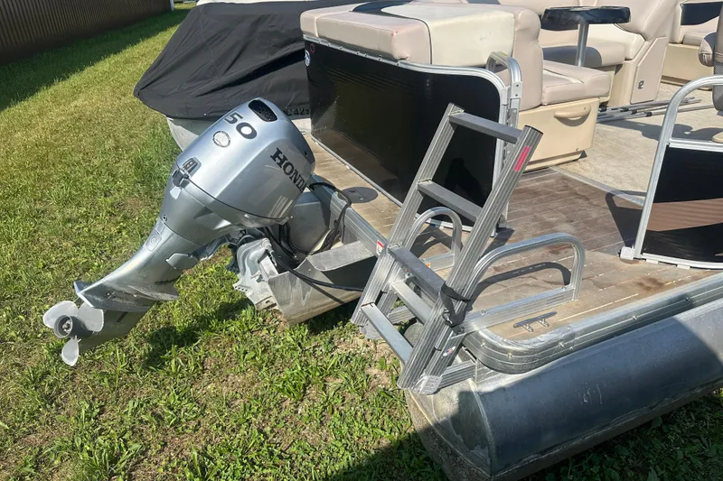Slide: The Image of 2013 Sweetwater 2086 RE pontoon boat with Honda outboard motor and ladder on grass. - 16