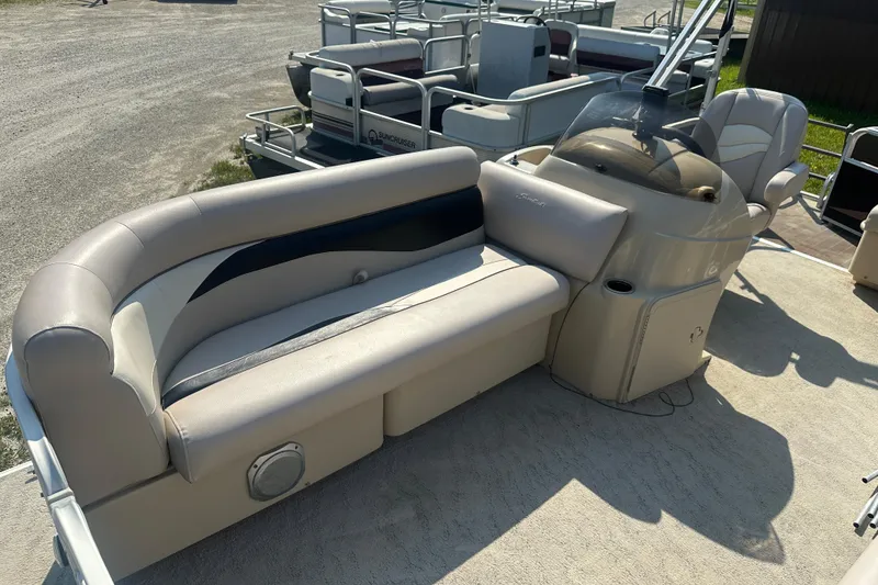 Slide: The Image of 2013 Sweetwater 2086 RE pontoon boat interior with beige seating and helm. - 4