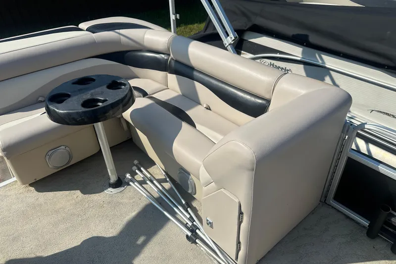 Slide: The Image of 2013 Sweetwater 2086 RE boat interior with beige seating and a black cup holder table. - 5