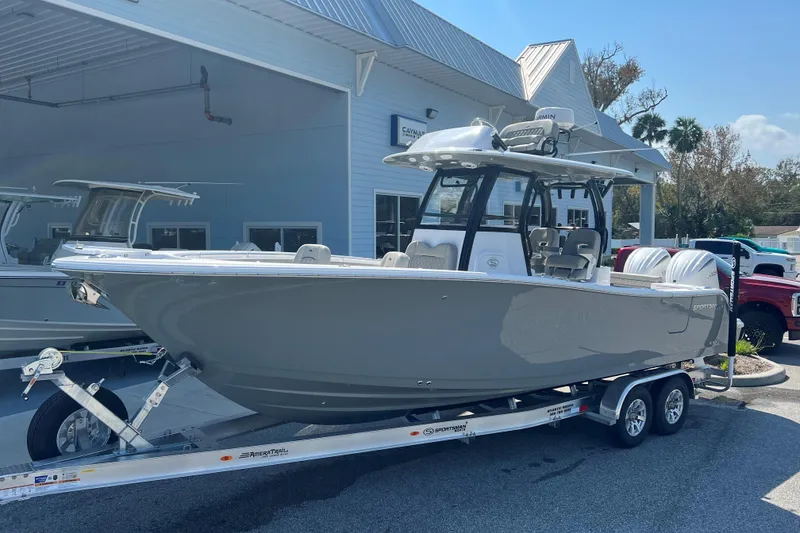 The Image of 2025 Sportsman Open 282 Center Console boat on trailer, parked near palm trees. - 0