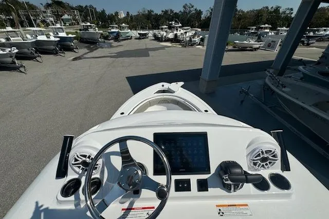 Slide: The Image of 2025 Sportsman Open 282 Center Console boat dashboard with steering wheel and digital display. - 10