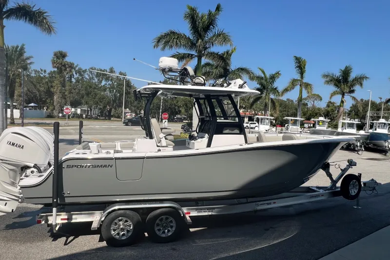 Slide: The Image of 2025 Sportsman Open 282 Center Console boat with dual Yamaha engines, parked outdoors. - 2