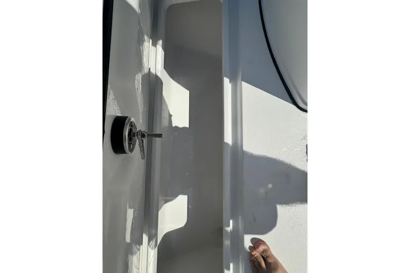 Slide: The Image of 2025 Sportsman Open 282 Center Console interior detail with key and compartment. - 21