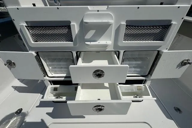 Slide: The Image of 2025 Sportsman Open 282 Center Console storage compartments with open drawers and netted shelves. - 28