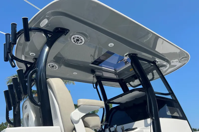 Slide: The Image of 2025 Sportsman Open 282 Center Console boat with T-top and rod holders under clear sky. - 3