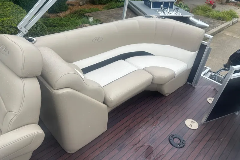 Slide: The Image of 2013 Harris Solstice 220 boat interior with beige seating and wooden flooring. - 10