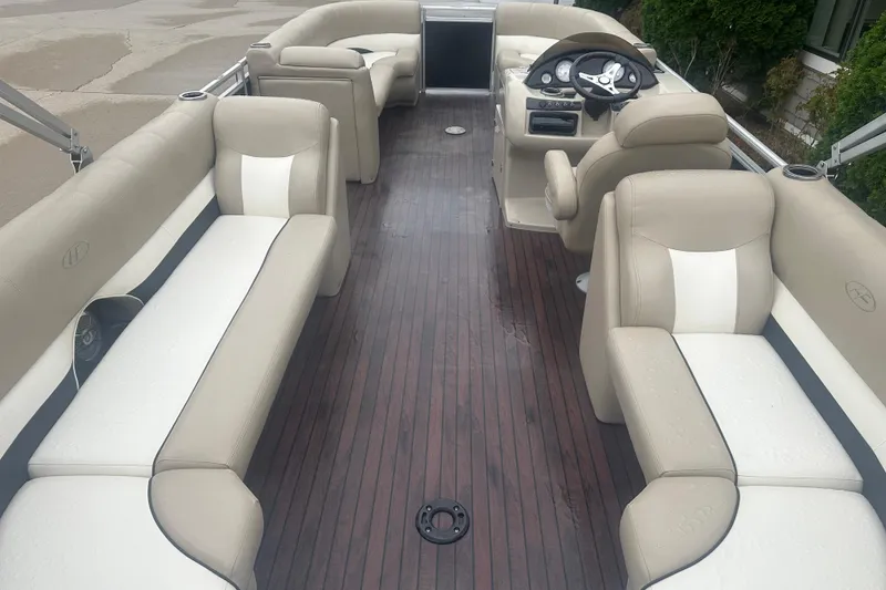 Slide: The Image of 2013 Harris Solstice 220 boat interior with beige seating and wood flooring. - 11