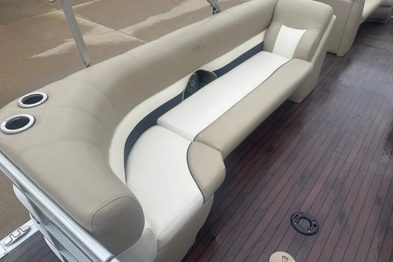 Slide: The Image of 2013 Harris Solstice 220 boat interior with beige and white seating on wooden deck. - 13
