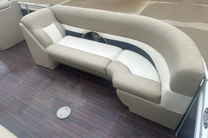 Slide: The Image of 2013 Harris Solstice 220 boat interior with beige seating and wooden flooring. - 4