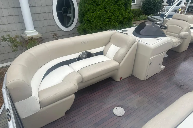Slide: The Image of 2013 Harris Solstice 220 boat interior with beige seating and wood flooring. - 5