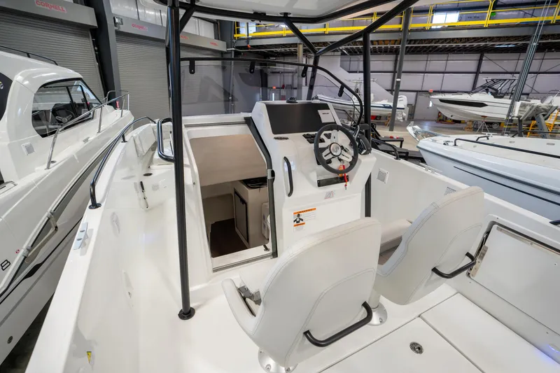 Slide: The Image of 2023 Beneteau Flyer 8 SPACEdeck interior with helm and seating in a showroom. - 10