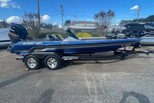 Slide: The Image of 2012 Skeeter ZX20 boat with trailer, parked outdoors on a sunny day. - 3