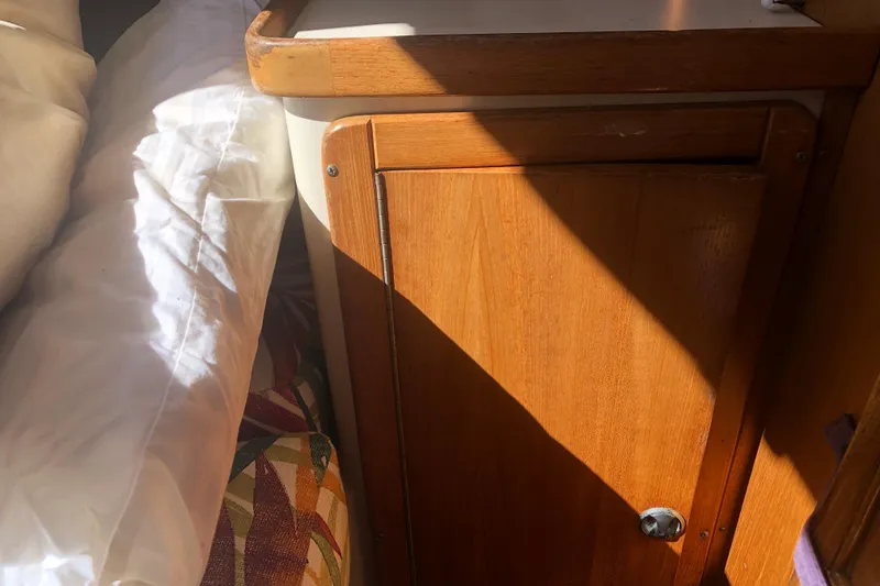 Slide: The Image of Wooden cabinet in a 2001 Catalina 34 Mk II sailboat interior, with sunlight casting shadows. - 18
