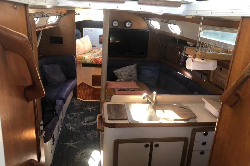 Slide: The Image of Interior of 2001 Catalina 34 Mk II sailboat with cozy seating and compact kitchen area. - 9