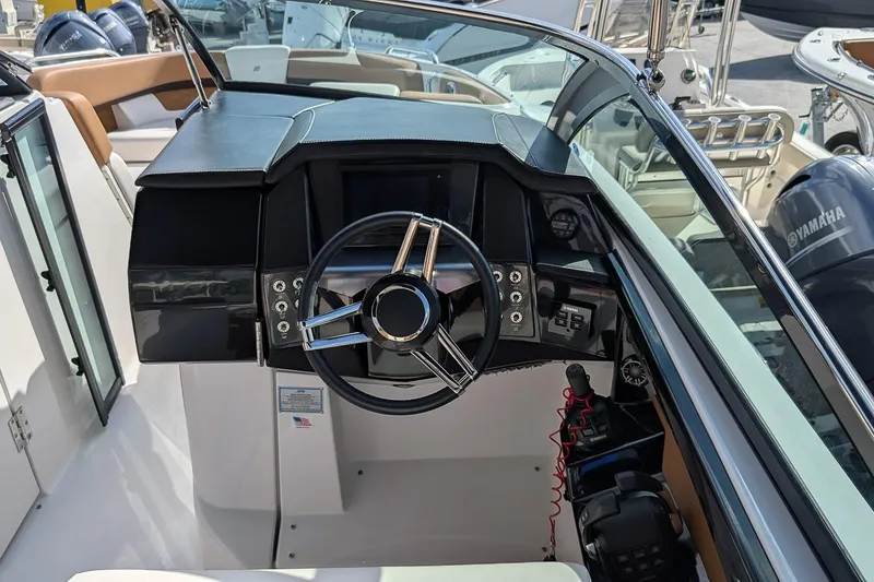 Slide: The Image of 2019 Four Winns H290 OB boat cockpit with steering wheel and controls. - 12