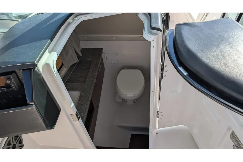 Slide: The Image of 2019 Four Winns H290 OB boat interior with compact bathroom and toilet. - 15