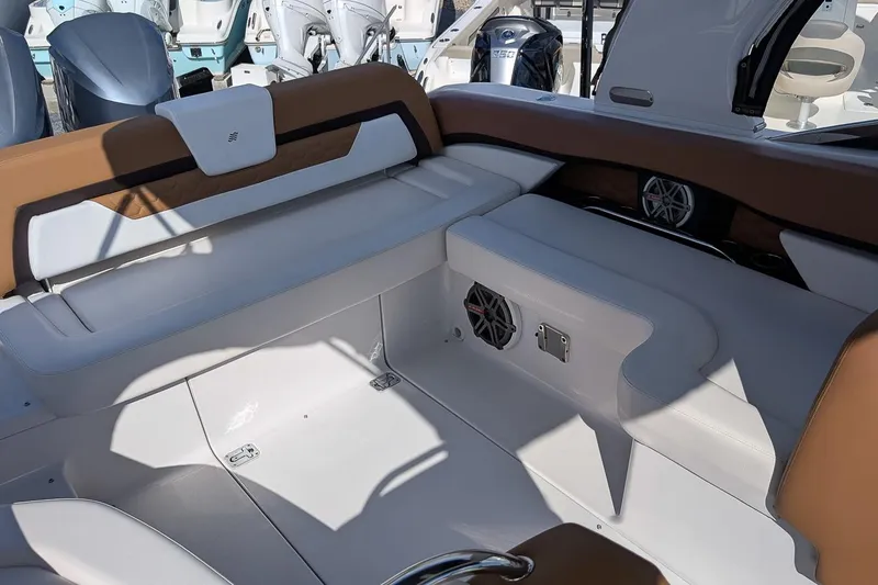 Slide: The Image of 2019 Four Winns H290 OB boat interior with white and brown seating, speakers, and outboard motors. - 7