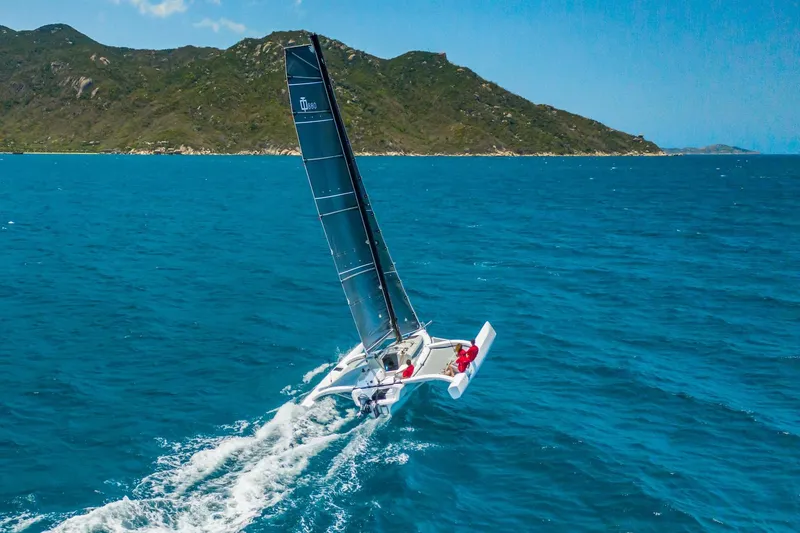 The Image of Corsair 880 Sport 2022 sailing in blue ocean near lush green island. - 0
