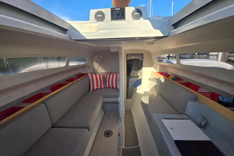 Slide: The Image of Interior of 2022 Corsair 880 Sport sailboat with modern seating and storage. - 10