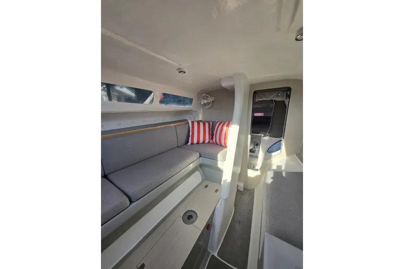 Slide: The Image of Interior of 2022 Corsair 880 Sport sailboat with gray seating and striped cushions. - 11