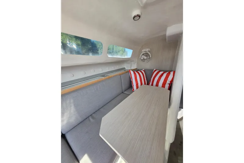 Slide: The Image of Interior of 2022 Corsair 880 Sport sailboat with cozy seating and striped cushions. - 12