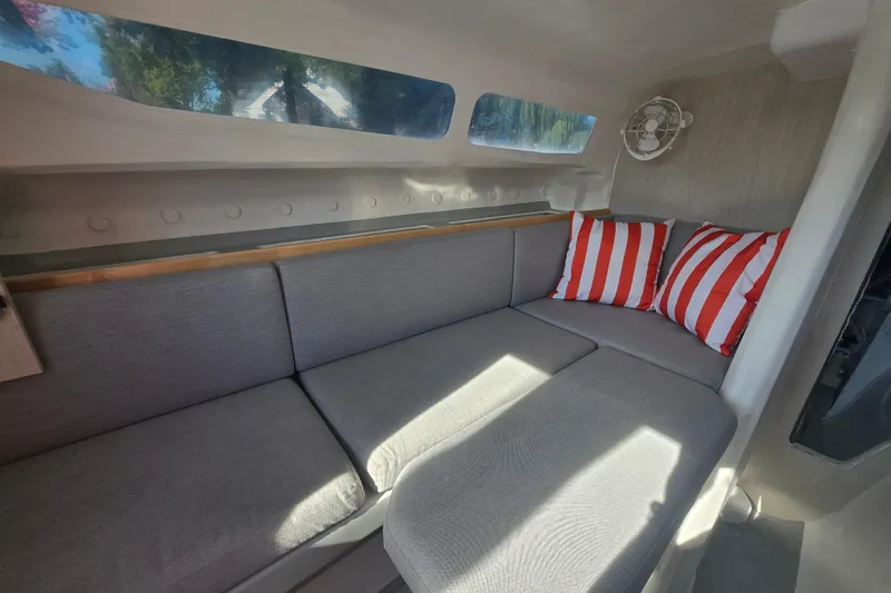 Slide: The Image of Interior of 2022 Corsair 880 Sport boat with gray seating and striped pillows. - 13