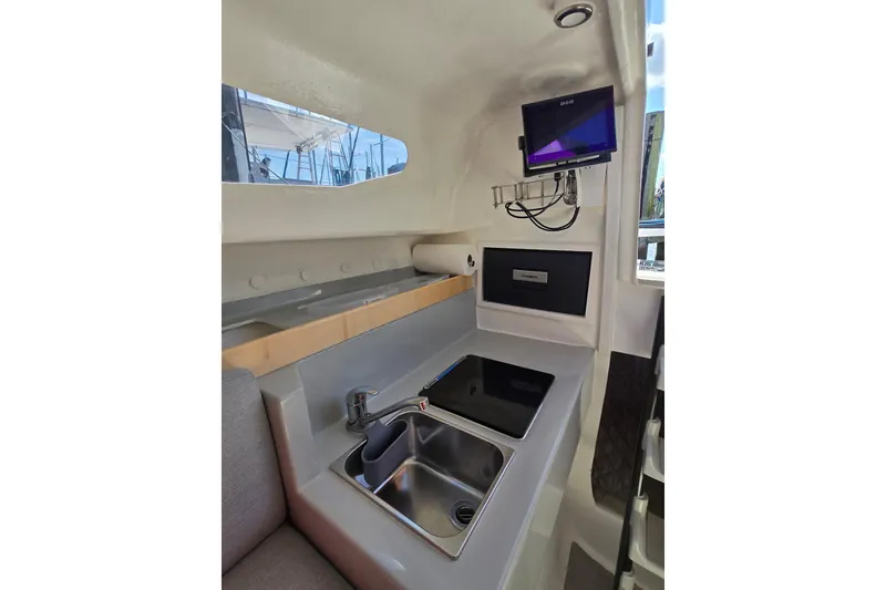 Slide: The Image of Interior of 2022 Corsair 880 Sport boat featuring a compact kitchen area. - 15