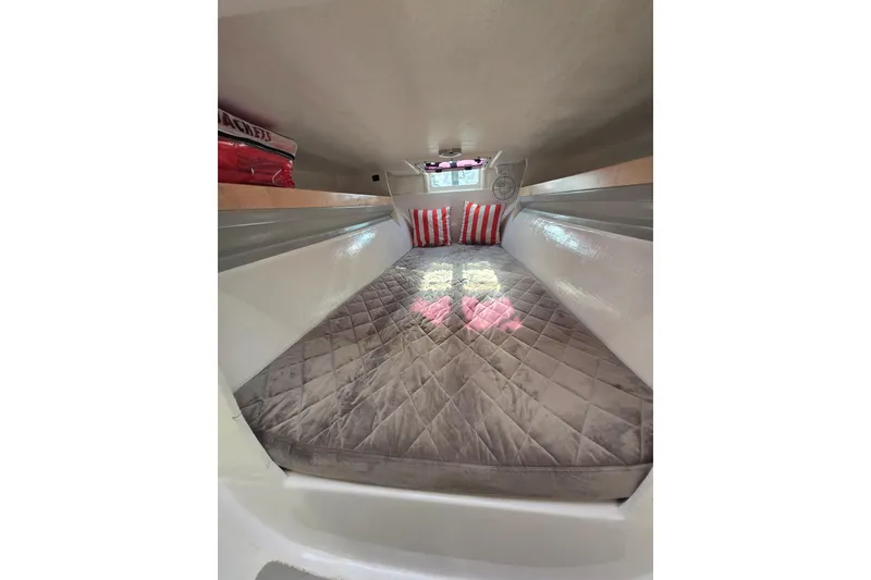 Slide: The Image of Cozy interior cabin of 2022 Corsair 880 Sport with quilted bedding and striped pillows. - 16