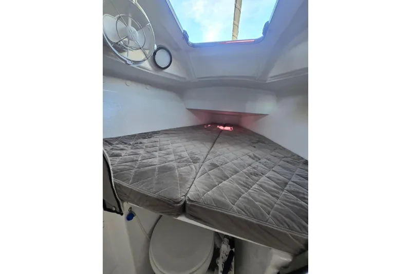 Slide: The Image of Interior cabin of 2022 Corsair 880 Sport sailboat with cushioned sleeping area. - 17