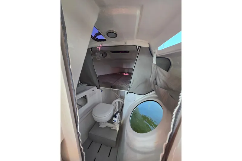 Slide: The Image of Interior of 2022 Corsair 880 Sport boat featuring compact cabin with toilet and bed. - 18