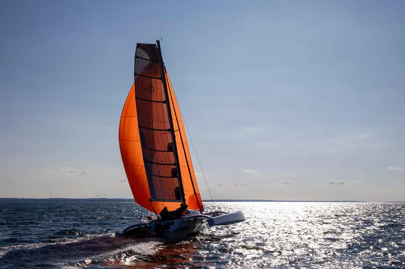 Slide: The Image of Sailing Corsair 880 Sport 2022 with vibrant orange sail on open water. - 3