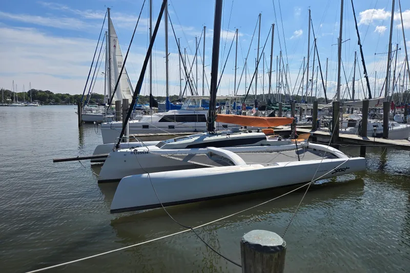 Slide: The Image of 2022 Corsair 880 Sport sailboat docked in a marina with other boats. - 4