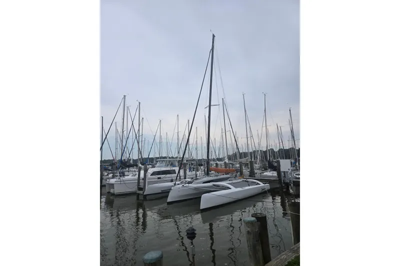 Slide: The Image of 2022 Corsair 880 Sport sailboat docked among other boats in a marina. - 7