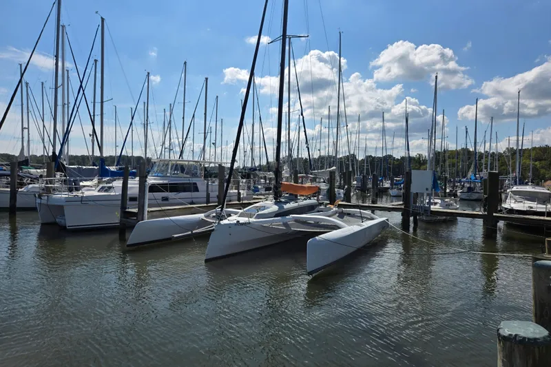 Slide: The Image of Sailboats docked at marina, featuring 2022 Corsair 880 Sport under clear blue sky. - 8