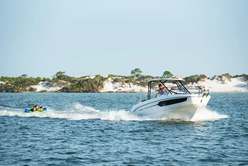 Slide: The Image of 2023 Beneteau Flyer 8 SUNdeck cruising on water, towing a tube with passengers. - 11