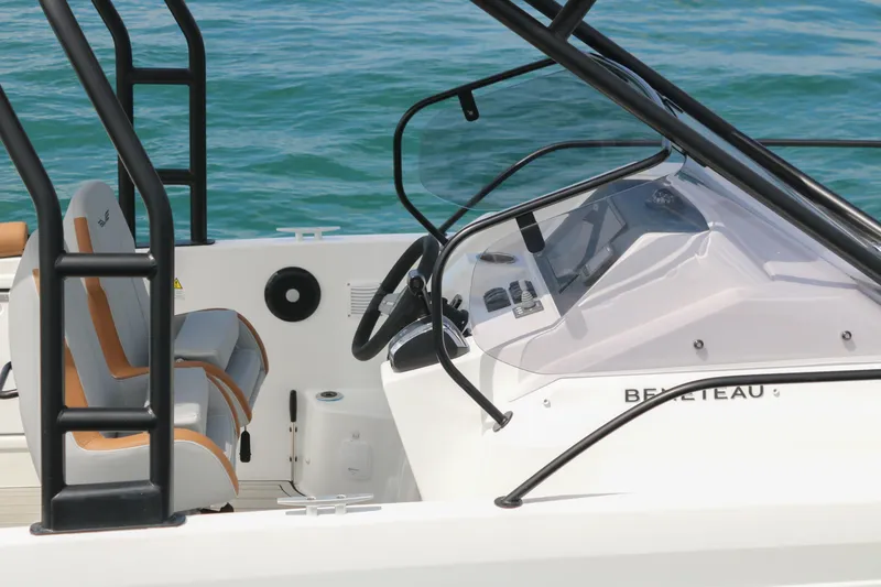 Slide: The Image of 2023 Beneteau Flyer 8 SUNdeck boat cockpit with steering wheel and seating, on clear blue water. - 14
