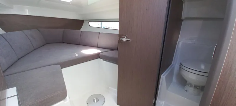 Slide: The Image of 2023 Beneteau Flyer 8 SUNdeck interior with cozy seating and compact bathroom. - 6