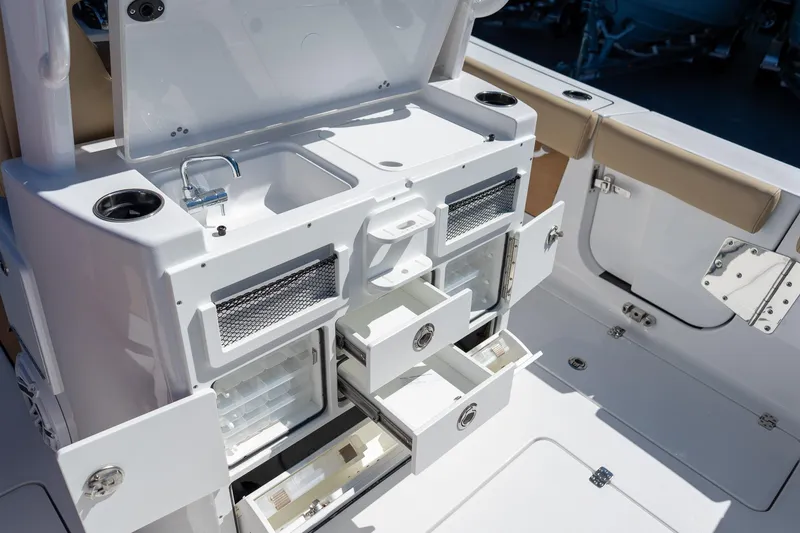 Slide: The Image of 2026 Sportsman Open 282 Center Console boat interior with sink, storage, and seating. - 28