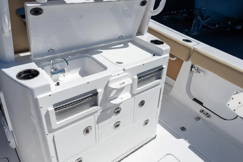 Slide: The Image of 2026 Sportsman Open 282 Center Console boat interior with sink and storage compartments. - 29