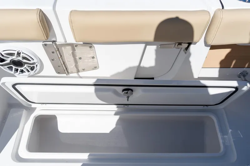 Slide: The Image of 2026 Sportsman Open 282 Center Console storage compartment with beige seating and speaker. - 38