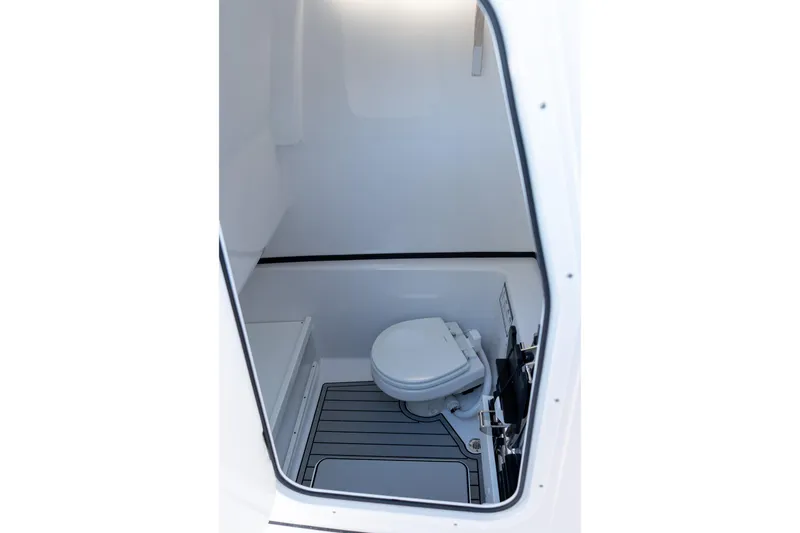 Slide: The Image of 2026 Sportsman Open 282 Center Console boat interior with compact marine toilet. - 51