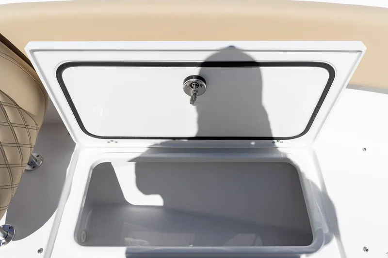 Slide: The Image of 2026 Sportsman Open 282 Center Console storage compartment with key lock, beige seating. - 56