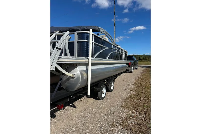 Slide: The Image of 2019 Bennington SX 22 Fishing pontoon boat on trailer under clear blue sky. - 13