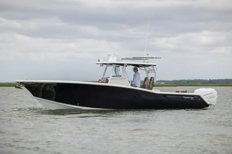 Slide: The Image of 2020 Tidewater 320 CC Adventure boat cruising on calm waters under cloudy skies. - 0