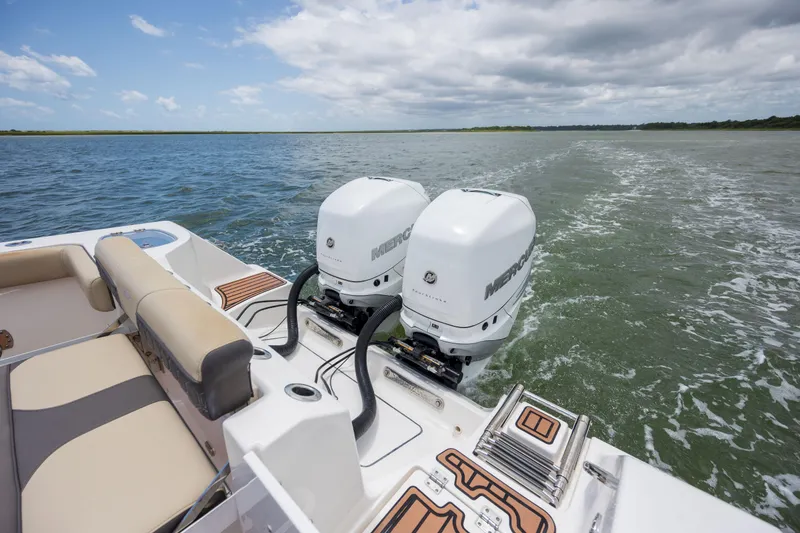 Slide: The Image of 2020 Tidewater 320 CC Adventure boat with dual Mercury outboard engines on open water. - 11